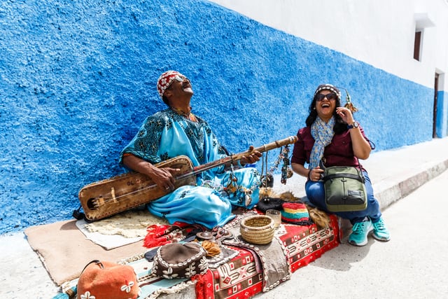 5 ways to have a life-changing travel experience 25 Intrepid Travel-MOROCCO_RABAT_local_musician_pax_laugh-2