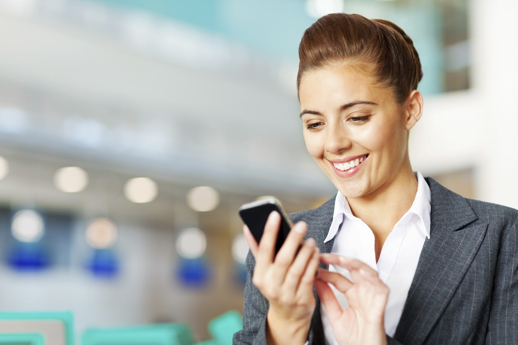 The Daily Travel Agent Bite: Tues 14 Mar 33 Happy young businesswoman sending text message on mobile phone. Horizontal Shot.