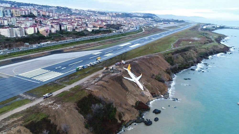 Plane skids off runway & hangs from the side of a cliff