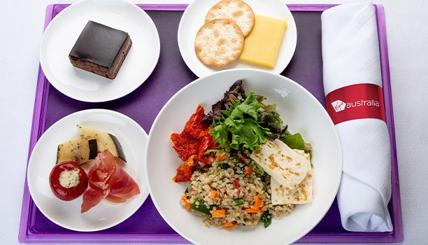 Haloumi and quinoa salad served alongside an antipasto plate with marinated vegetables, cheese and crackers and a chocolate delight cake: Business Class