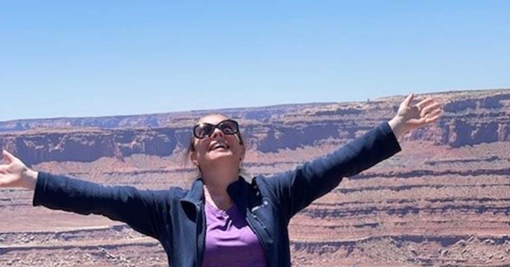TravelManagers participate as Signature Travel Network undercover agents for third straight year in 2025 2 Woman with outstretched arms in Dead Horse Canyon Park, USA.
