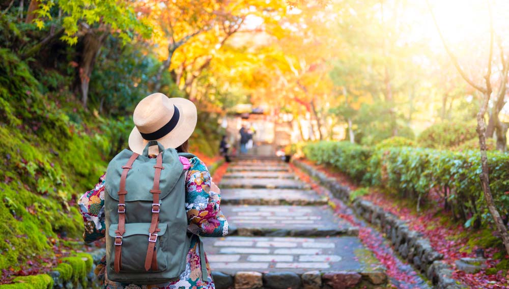 Woman walking in Kyoto garden in Japan.