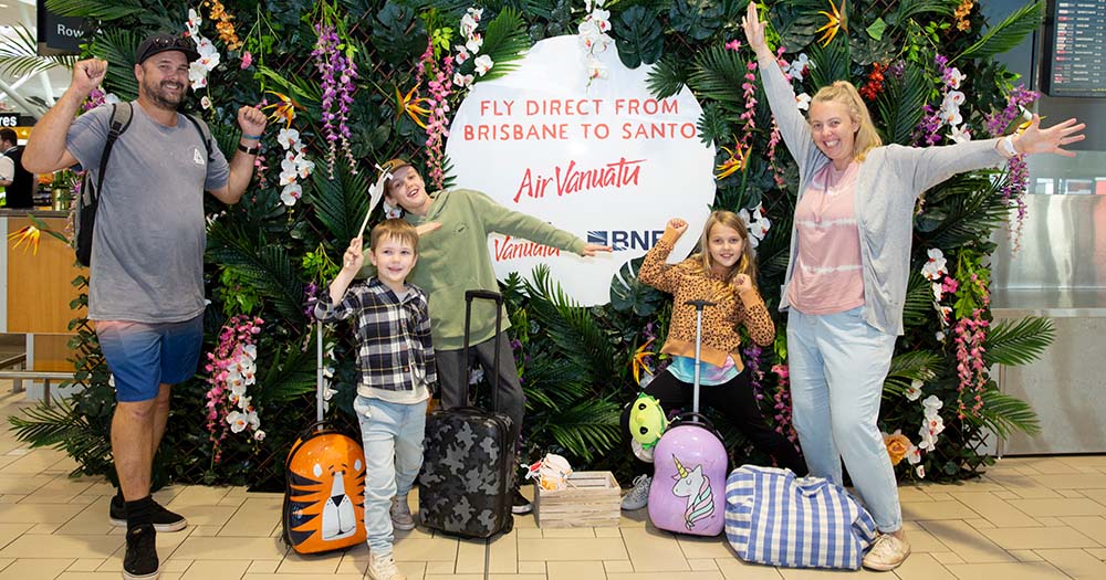 Family at Brisbane Airport in front of promotional backdrop