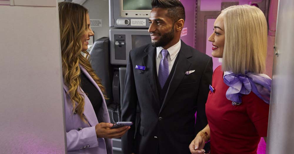Virgin Australia cabin crew greet customer on board.