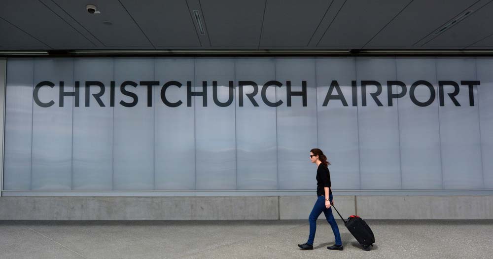 No-go to Goldie: Air New Zealand to pause this direct trans-Tasman link until March 2026 1 Woman with suitcase walking under Christchurch Airport sign