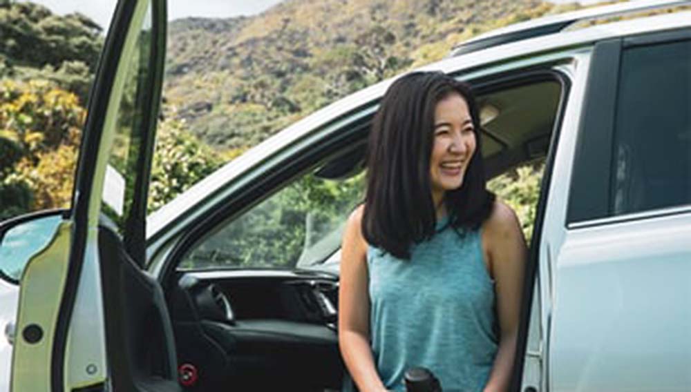 NZ border reopening 1 year on; TIA reflects on "rollercoaster" tourism recovery 2 Smiling women in car with door open in nature
