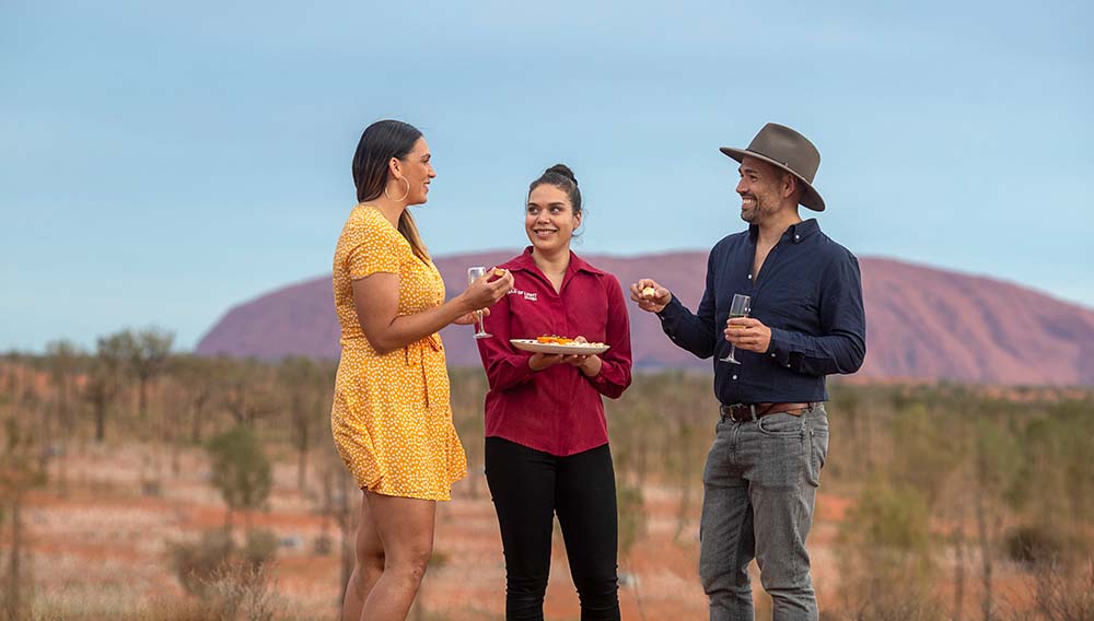 TNT People enjoying sunset drinks and canapes in front of Uluru credit Tourism NT Rhett Hammerton 133725 19