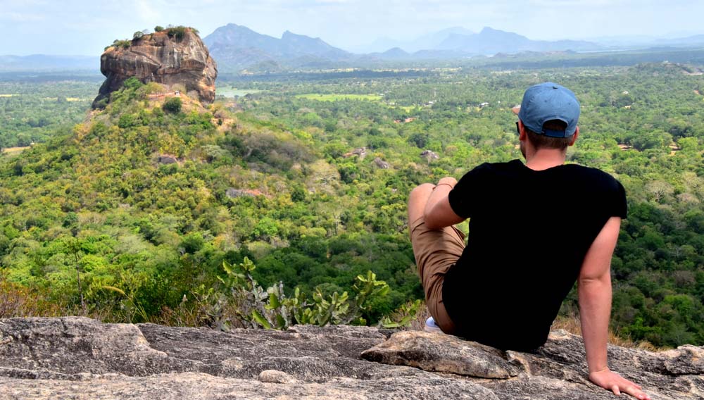 Backpacker on Pidurangala Rock with a nice view of Sigiriya Rock Sri Lanka shutterstock 729425743