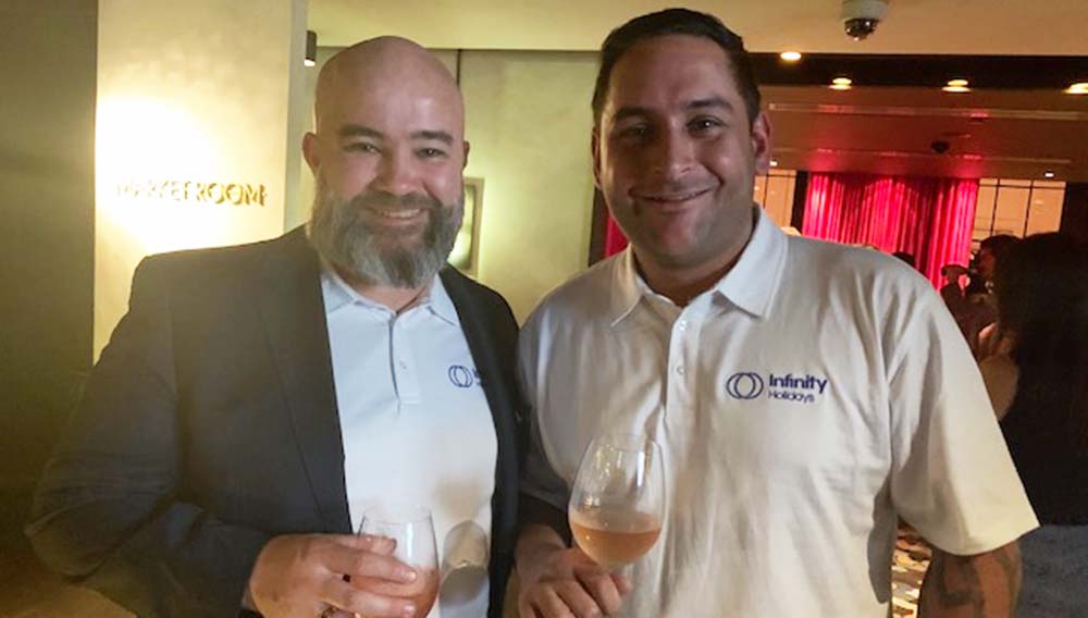 Two men holding wine at cocktail event