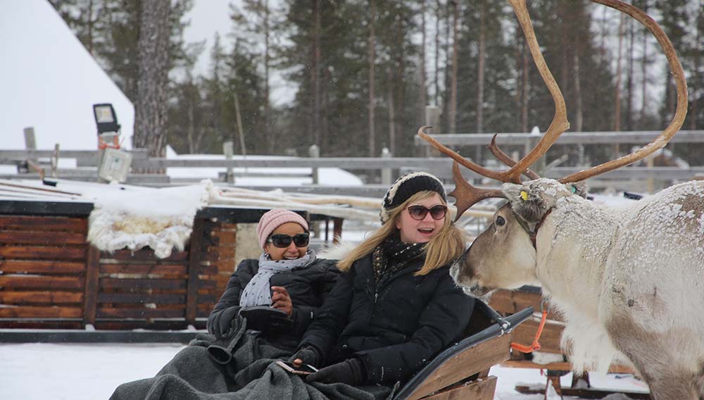 Travellers on a reindeer safari in the snow in Finland with Collette