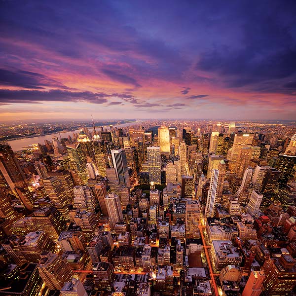 Viva Holidays NYC famil featuring the Manhattan skyline at night.