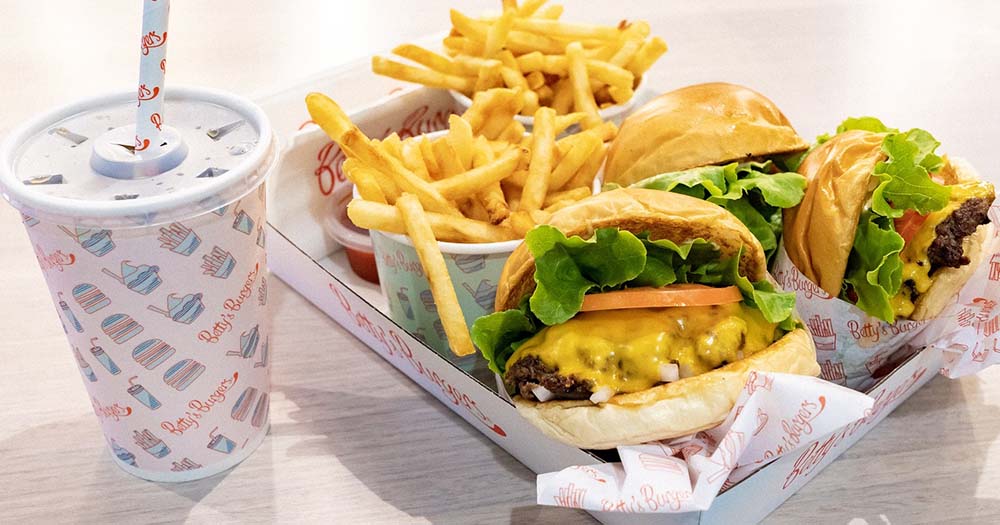 Close-up of burgers, fries and a shake on a table at Sydney Airport.