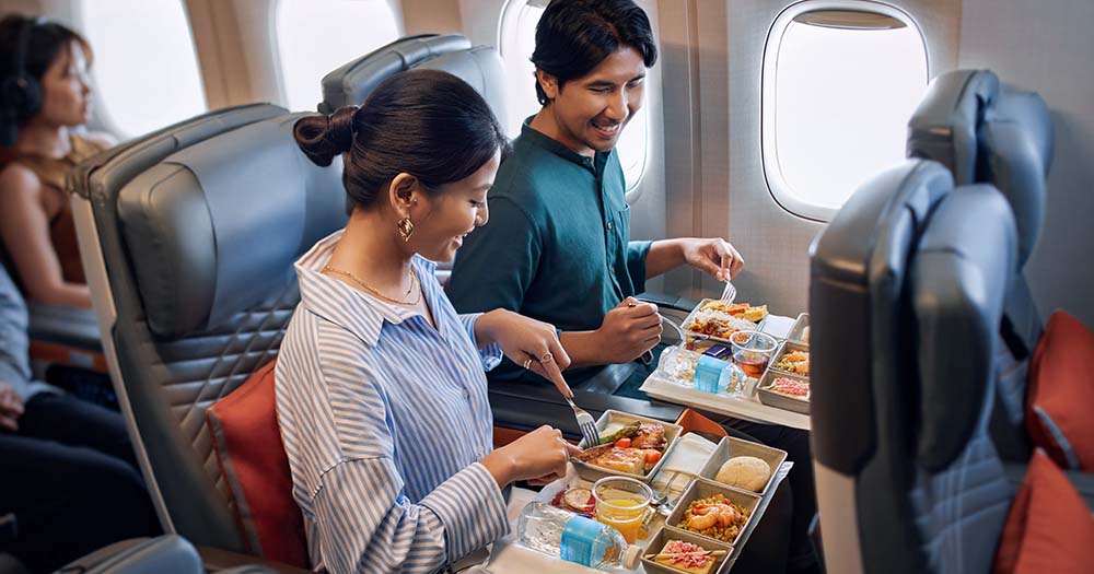 Couple in Singapore Airlines Premium Economy seats with special meals.