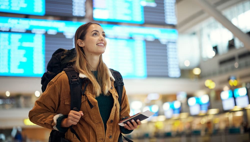 Young female backpacker in airport shutterstock 2259995365