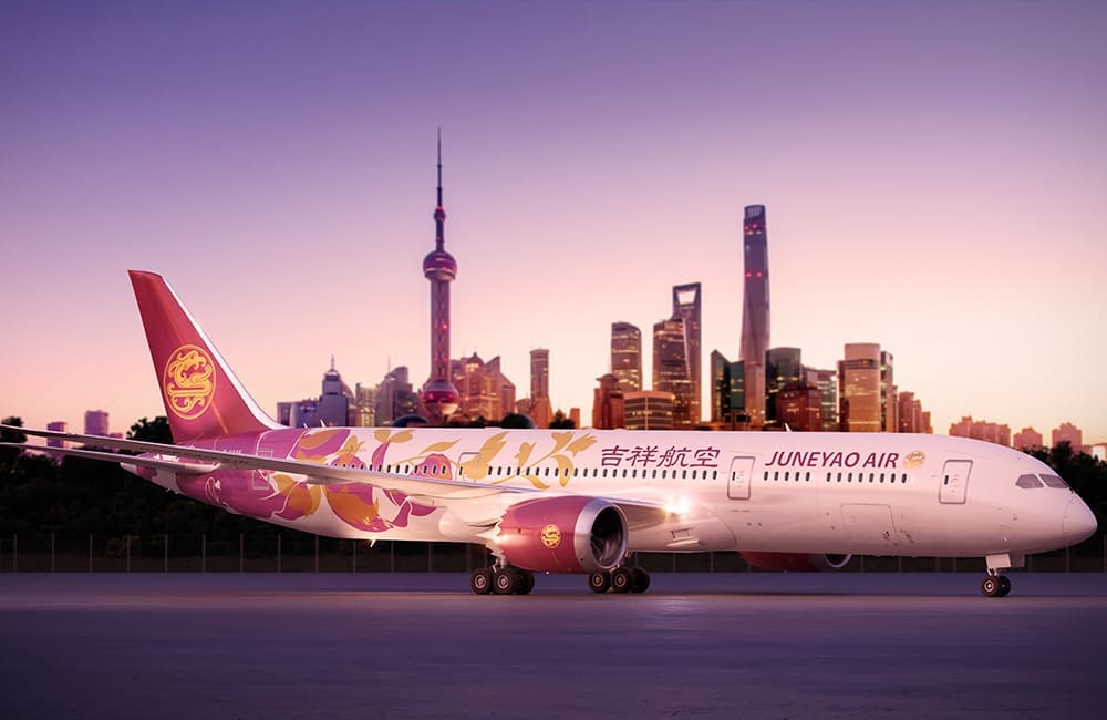 Juneyao Air aircraft against Shanghai skyline.