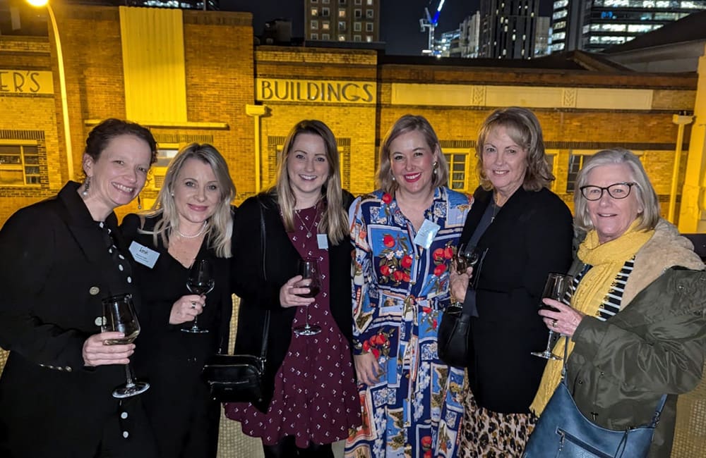 Group of travel professionals on rooftop at night for Link Travel Group event in Perth.