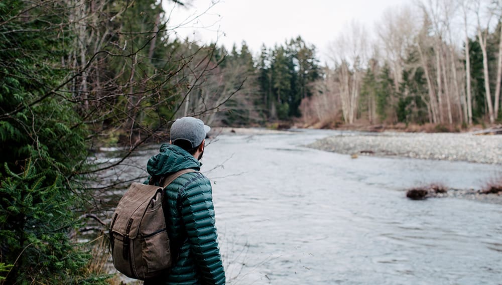 A man stands beside the Englishman River overlooking the estuary on Vancouver Island. Image: Parksville Qualicum Beach/Jordan Dyck – Travel With Purpose Ambassador competition