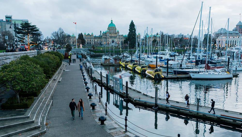 Aerial shot of couple walking near harbour in Victoria, Vancouver Island in winter. Image: Destination BC/Jordan Dyck