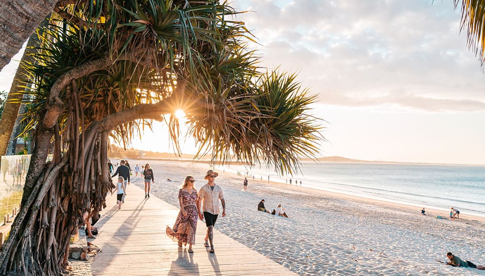 Couple walking on the boardwalk at Noosa Heads Main Bach on the Sunshine Coast.