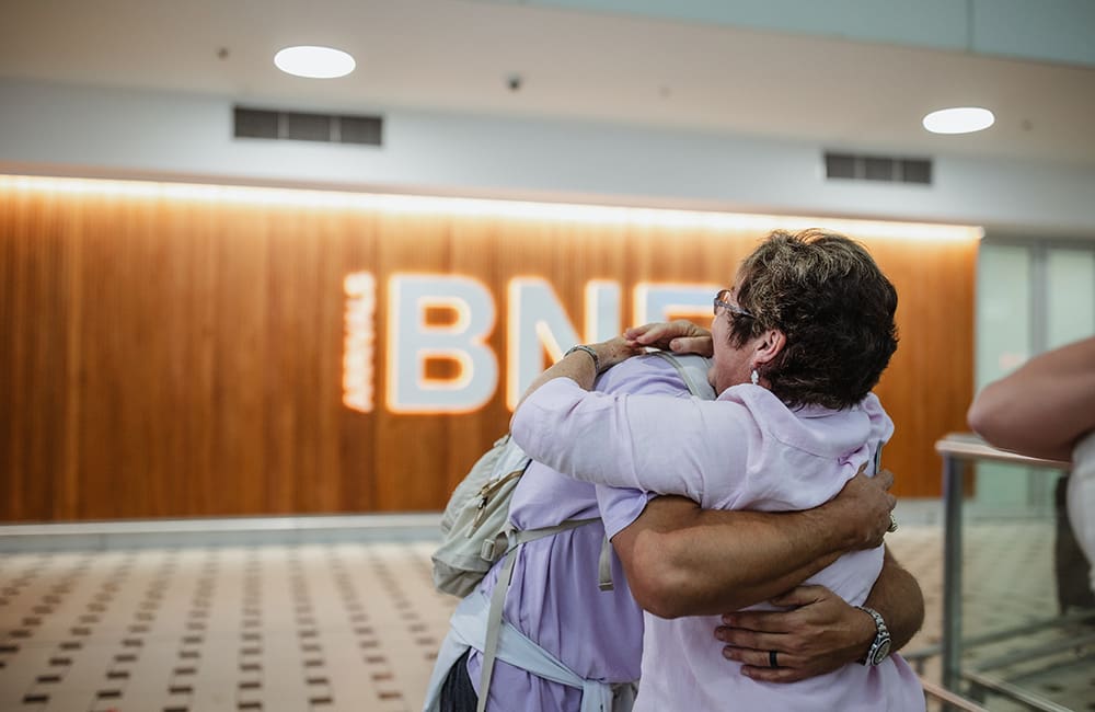 People embrace at Brisbane Airport.