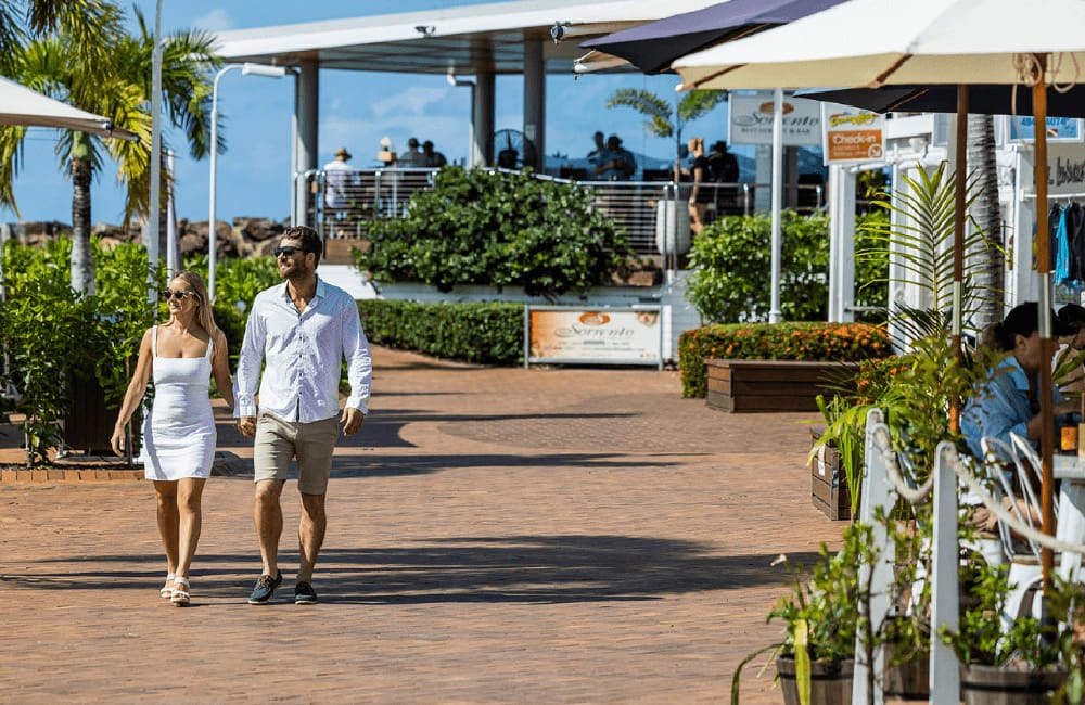 Couple walking in the marina village at Coral Sea Marina.