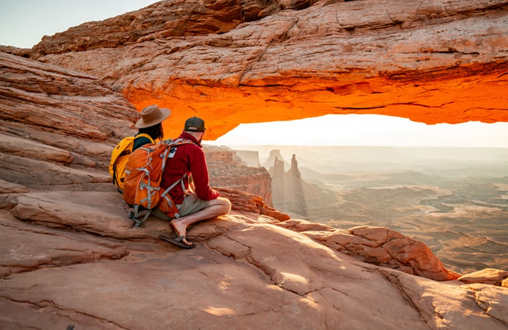 Couple at overhanging rock at Canyonlands National Park, Utah. VR road trip at USA House