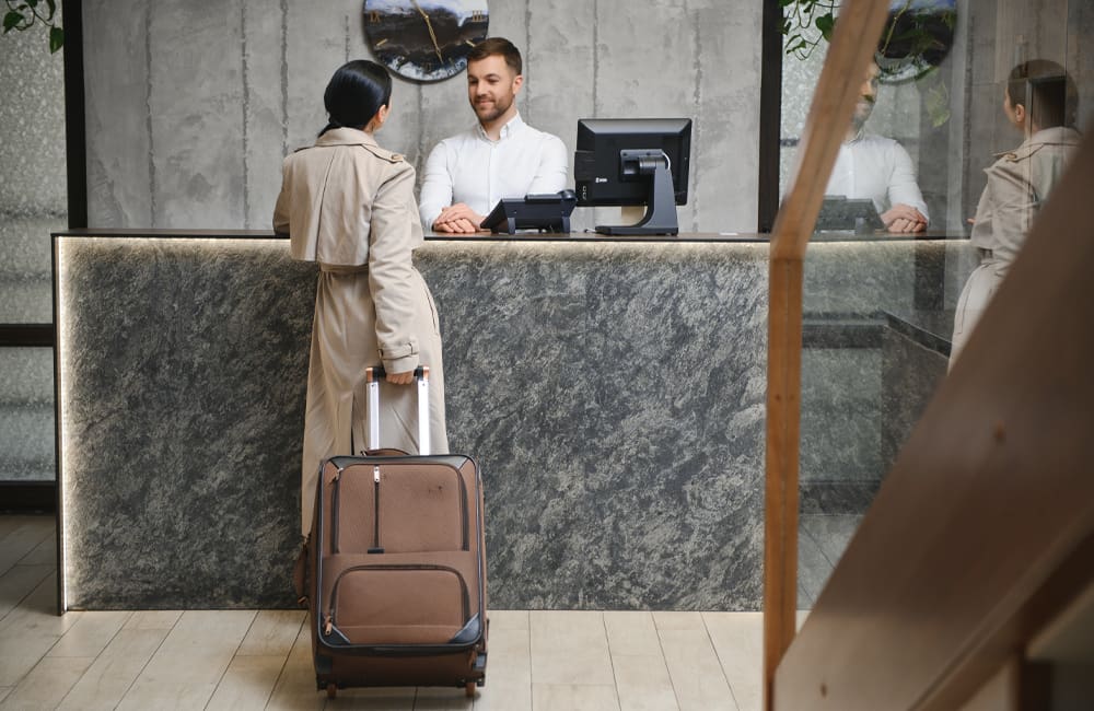 Woman checking into hotel. Image: Shutterstock