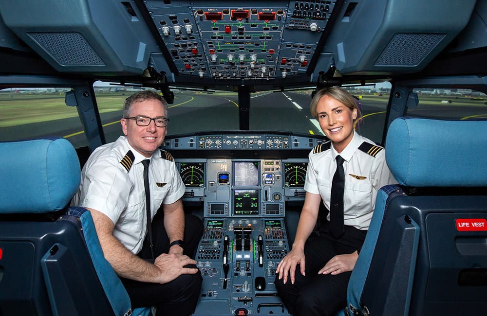 Two Qantas instructors inside flight simulator machine at Sydney Flight Training Centre.