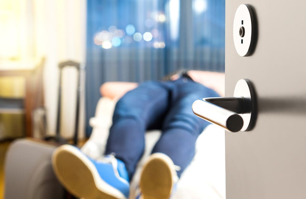 Sick traveller laying on hotel bed –  common overseas illnesses and injuries Image: Shutterstock
