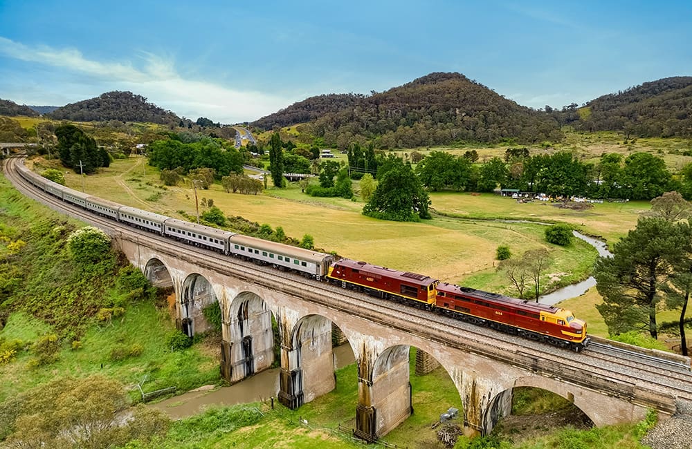 Vintage Rail Journeys train from above on bridge in NSW. Image: Chris Ersek