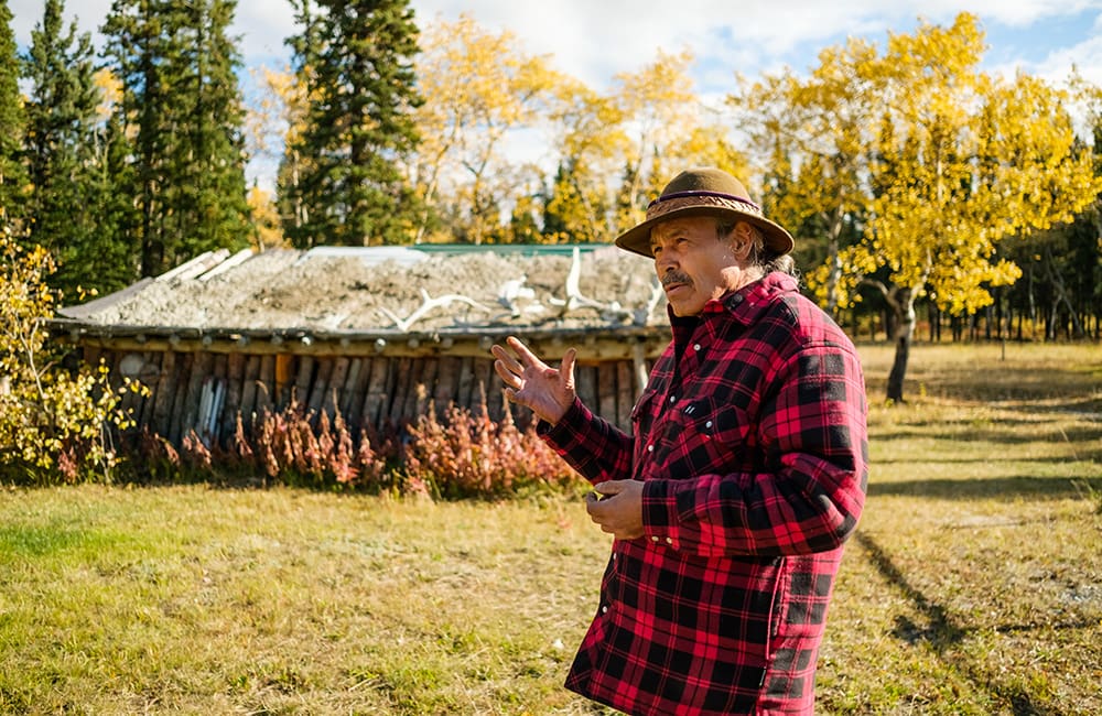 Southern Tutchone First Nations guide outside a tradtional dwelling at Long Ago Peoples Place in the Yukon. Image: Destination Canada