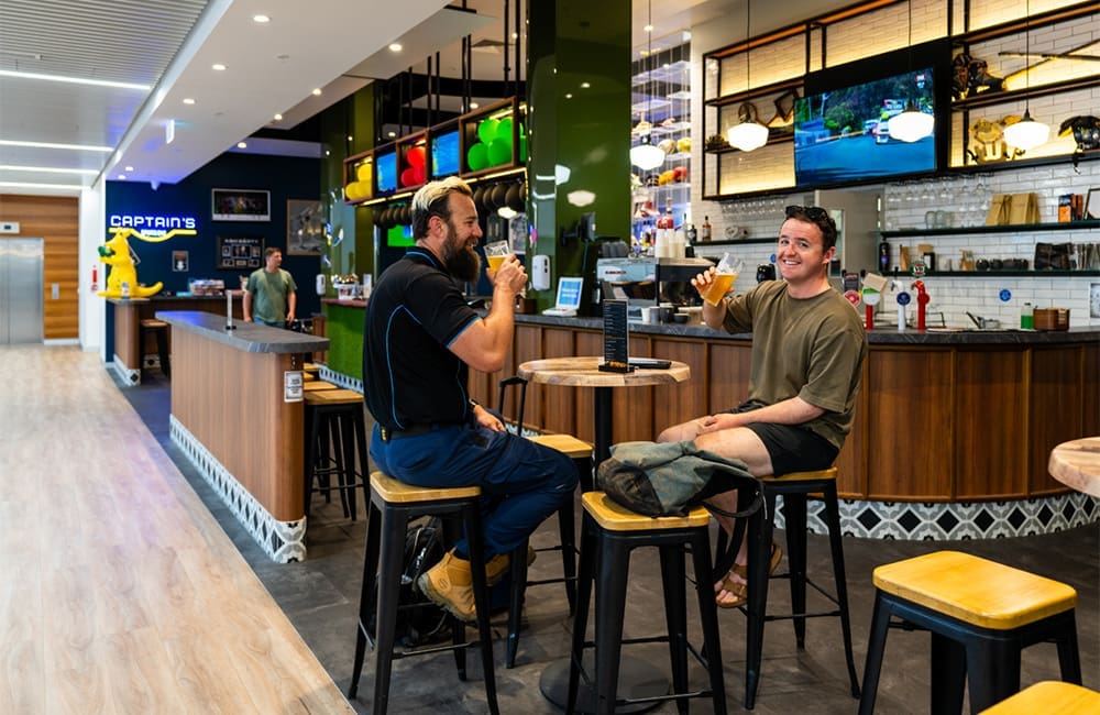 Two men drinking beer in an airport bar at Cairns Airport.