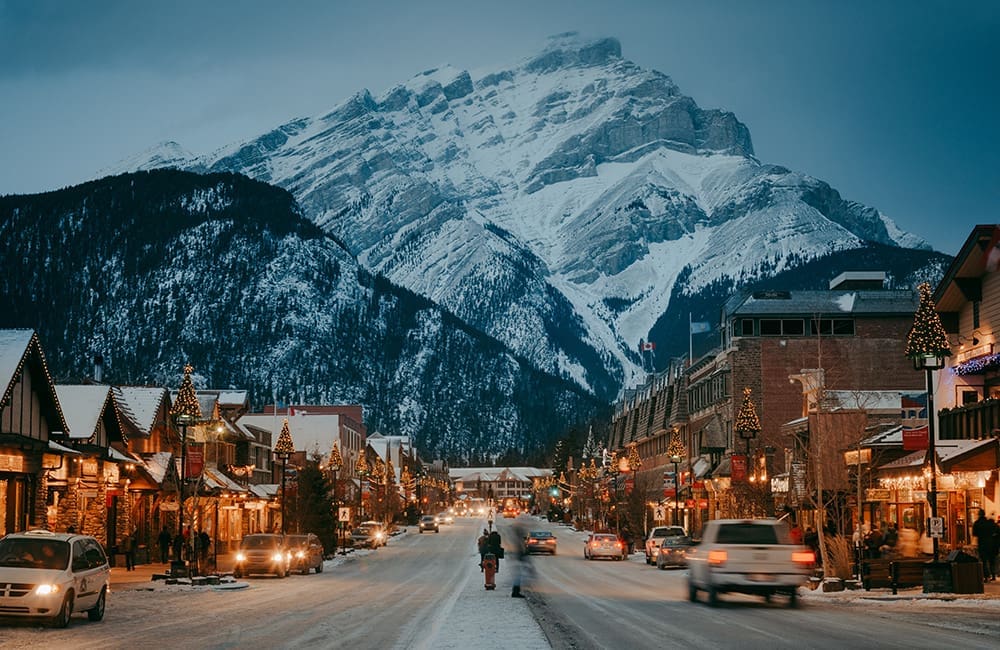 Downtown Banff at dusk with Christmas decorations on street.