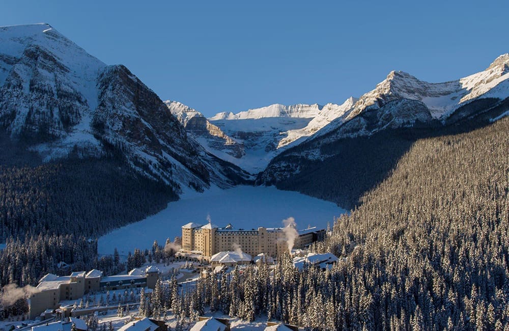 Aerial view of Fairmont Chateau Lake Louise in winter covered in snow.