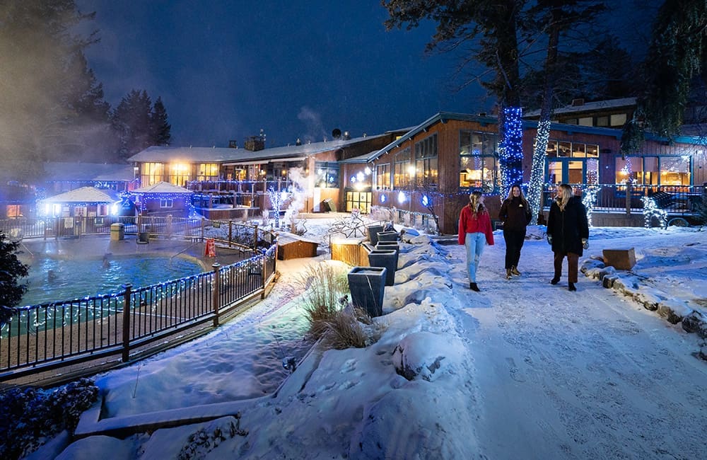 Women walk past the outdoor hot springs at Fairmont Hot Springs in BC. Image: Kootenay Rockies Tourism/Mitch Winton
