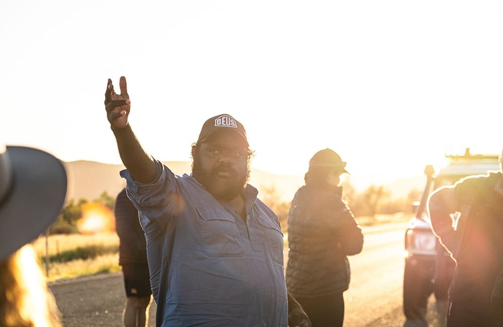 100% Finke River Culture & Adventure Trip Leader Benjamin Kenny presenting to tour group at sunset.
