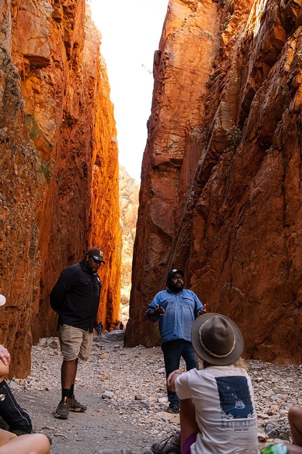 100% Finke River Culture & Adventure Trip Leader Benjamin Kenny in a chasm in Central Australia with a tour group.