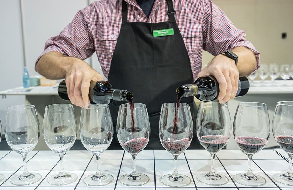 Bartender pouring red wine into glasses at the National Wine Show 2024.