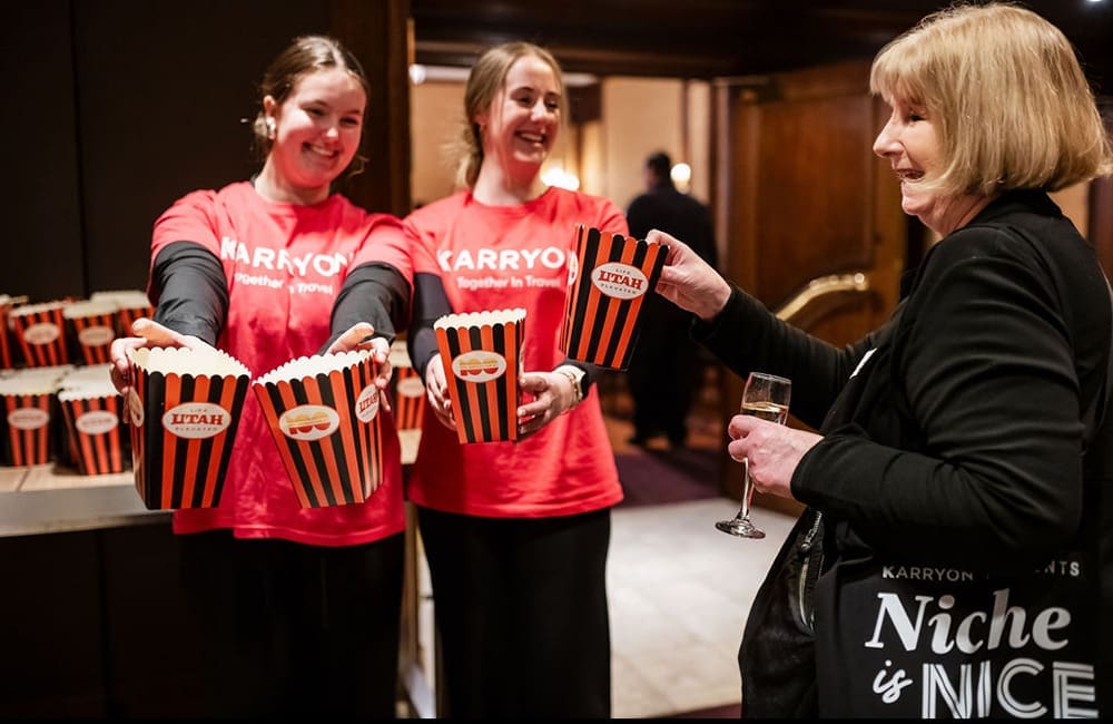 Two women in Karryon t-shirts hand out popcorn at Niche is Nice