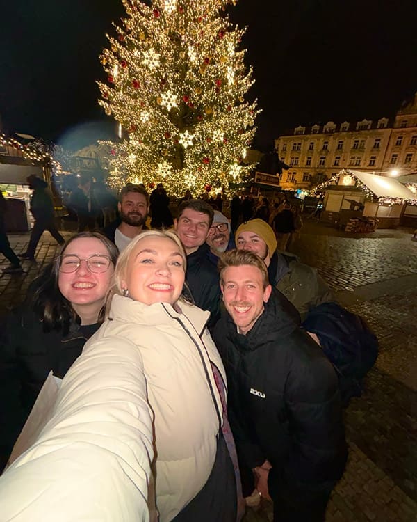 Topdeck travellers take a selfie in European town square in winter.
