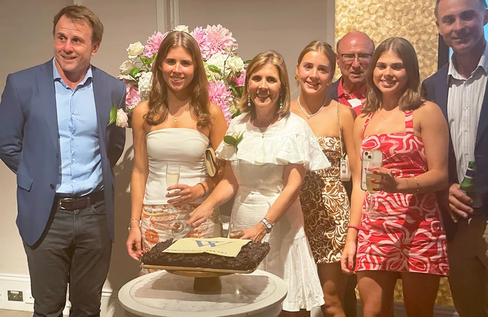 Wentworth Travel Managing Director Anna McMurtrie (centre in white) and her family cut the rocky-road celebration cake.