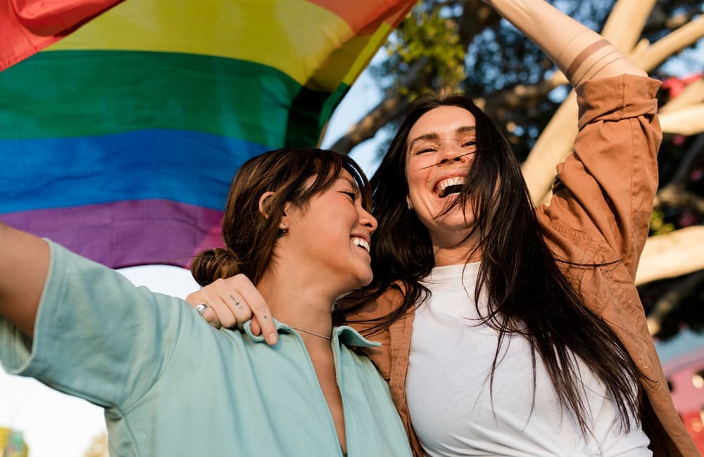 Female couple with rainbow flag – LGBTQIA+ tourism accreditation