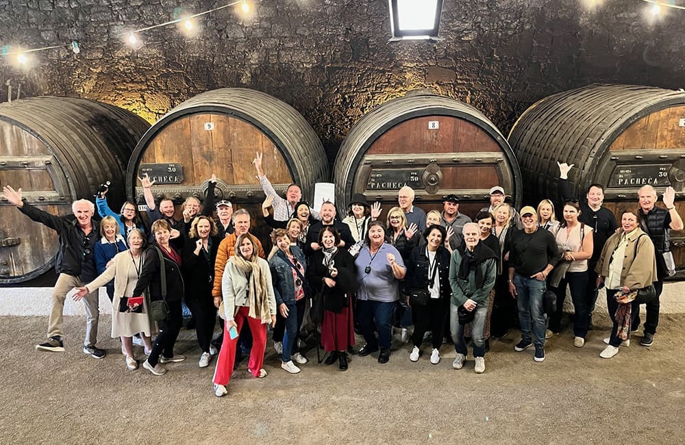 Group of people in a wine cellar with large barrels at Quinta da Pacheca in Portugal.