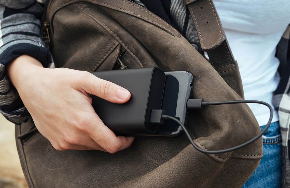 Close-up of female traveller charging a smartphone with a portable power bank. Karryon Top 10 Stories of the Week