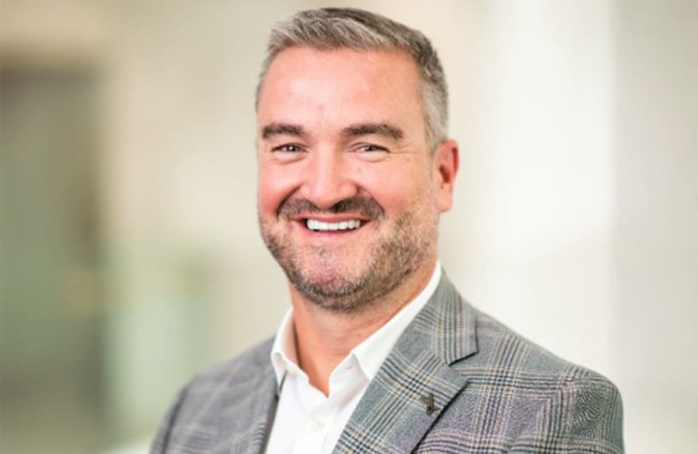 Corporate headshot of man in suit against blurred indoor background
Virgin Australia