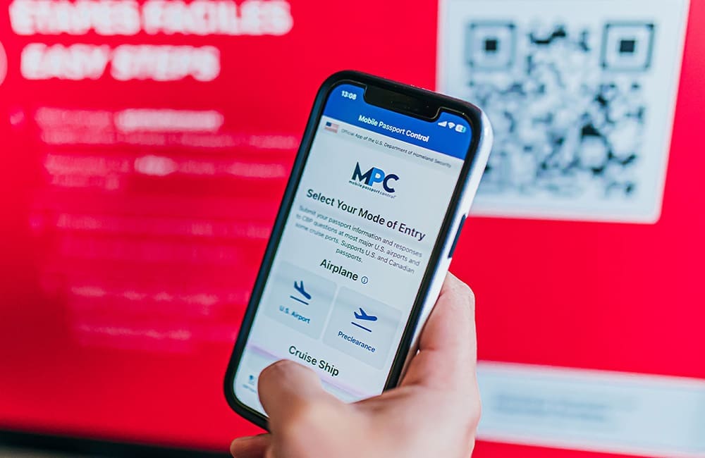 The Mobile Passport Control app on a smartphone held in a hand.