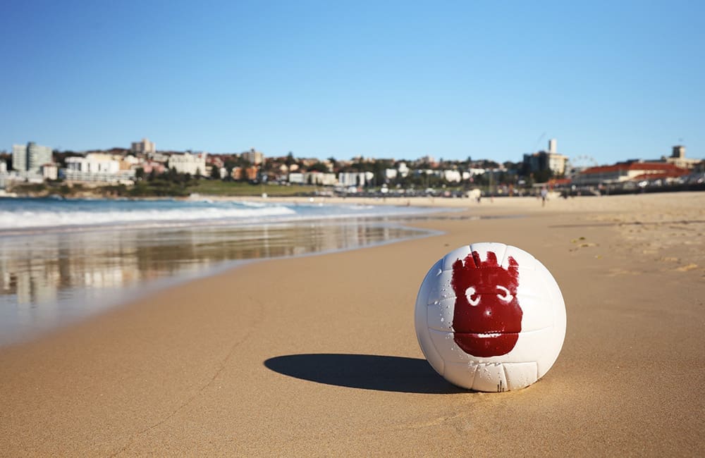 Wilson volleyball with red face handprint on an Australian beach for Tourism Fiji campaign