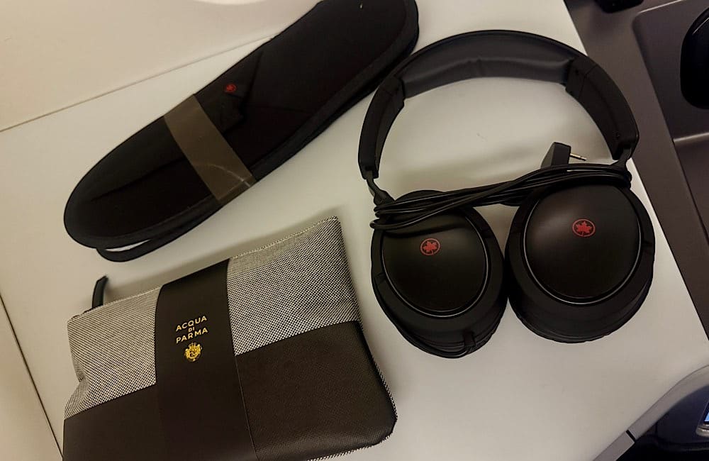 Acqua di Parma amenity kit, noise-cancelling headphones and slippers, provided to Signature Class passengers for comfort on the 15-hour Vancouver–Sydney flight.