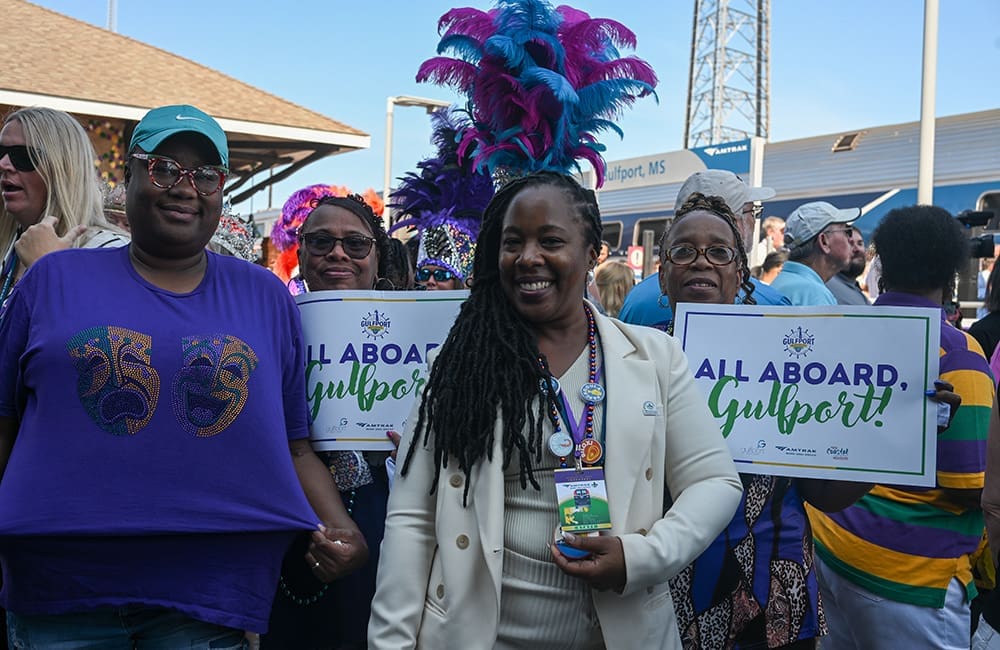Women holding Gulfport signs for the Amtrak Mardi Gras Service. Image: Larry Everage Jr