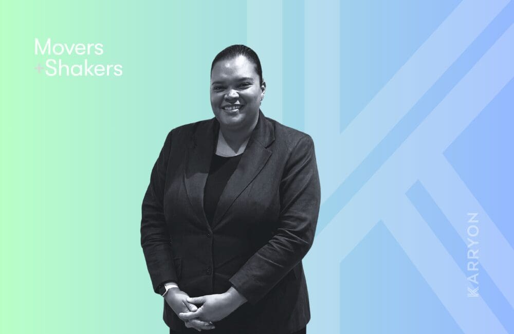 Corporate black-and-white headshot of woman against blue and green gradient background.